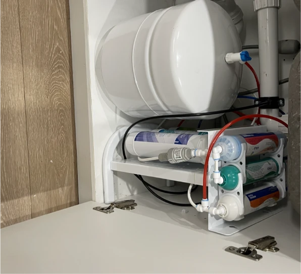 Water filtration system with multiple filter cartridges installed under a sink.